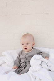 Soft, cozy gray merino wool onesie for babies 3-12 months. Features a comfortable, relaxed fit and gentle fabric for delicate skin.
