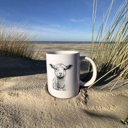 A white ceramic mug featuring a detailed illustration of a starfish against a blue background, surrounded by seashells and other beach elements.