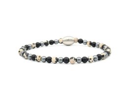 A black and white beaded bracelet with a mix of materials including metal, stone, and glass beads.