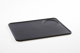 Rectangular black silicone tamper mat for barista accessories, suitable for food preparation.