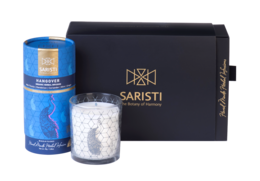 Organic herbal tea blend and assorted natural candle in a gift set. Includes a round, tall white candle with a hexagonal pattern.