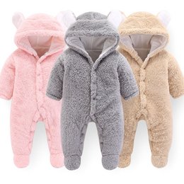 Soft, cozy baby romper in various colors including brown, grey, pink, and white. Features a hooded design with ears for a cute, cuddly look. Available in sizes 3M, 6M, 9M, and 12M.
