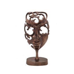 Vintage copper statue with intricate carved design featuring abstract facial features and floral motifs.