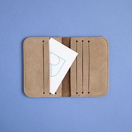 Taupe leather card sleeve with multiple card slots and a minimalist design.