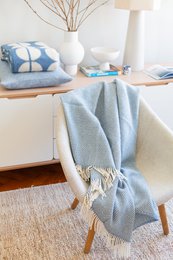  Soft, cozy blue wool blanket with fringe trim, perfect for adding warmth and style to any living space.