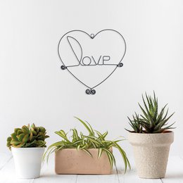 A heart-shaped metal frame with the word "LOVE" in the center, designed to be hung on a wall as wall decor or jewelry.