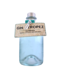 Gin Tropez 0.5L, a clear, light blue-green colored gin with a botanical garnish in a glass.