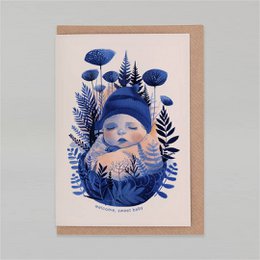 Whimsical, gender-neutral new baby card featuring a sleeping baby surrounded by blue mushrooms, ferns, and pine trees in a cozy, nature-inspired illustration.