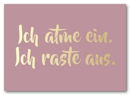 A pink postcard with the text "Ich atme ein. Ich raste aus." in a cursive yellow font.