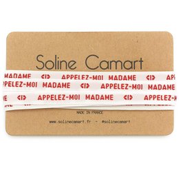 A pair of charm bracelet laces with the text "CALL ME MADAM" printed on them. The laces are made of a beige material and have a simple, minimalist design.