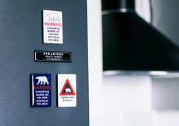 Rectangular enamel fridge magnet featuring the Svalbard reindeer, Gjelder Hele Svalbard, Svalbard Eider, Svalbard Lufthavn Longyearbyen, and Dangerous Marine Life designs in various colors. The magnet measures approximately 4x6 cm.