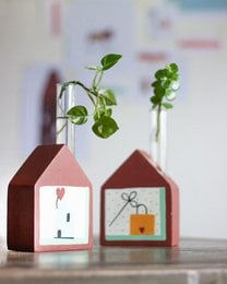 Red house-shaped wooden vases with glass test tubes, minimalist line drawings, bookend functionality, modern home decor.