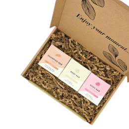 A gift set containing natural soap bars in a cardboard box with floral design.