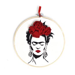  Embroidered portrait of Frida Kahlo with red flowers in her hair, displayed in a circular frame.