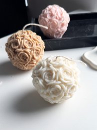 Decorative rose-shaped pillar candles in various pastel colors, including pink and cream. The candles have a textured, floral design that resembles roses.