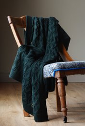  Soft, cozy merino wool throw in a deep green color with a lace leaf pattern. Ideal for adding warmth and texture to any living space.