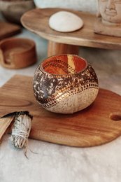 Decorative round candle holder with intricate patterns and textures, made of natural materials.