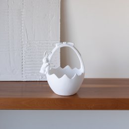 Small, decorative ceramic Easter baskets in white, cream, mint, and soft pink colors. The baskets have a unique, modern design with a curved handle.