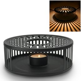 Black stainless steel tea warmer with a circular design and a tealight holder. Suitable for keeping tea warm.