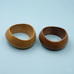 Large round wooden bangle bracelet, beige brown baroque style, natural wood material, wide chunky design.