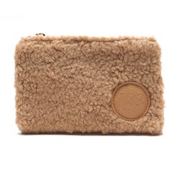  Beige fuzzy makeup pouch with zipper closure.