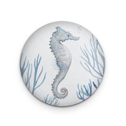 Decorative round magnet featuring a detailed illustration of a seahorse surrounded by coral in shades of blue and gray.