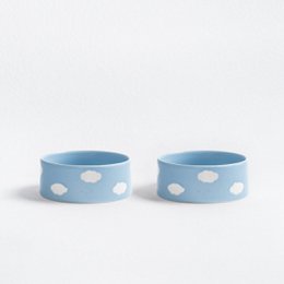  Two light blue pet bowls with white polka dots, suitable for dry pet food or water. Circular shape, approximately 14cm in diameter.