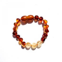 Baltic natural amber baby bracelet/anklet with amber beads in shades of orange, yellow, and red. The bracelet is designed to promote happiness and creativity in children.