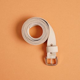 A nude-colored, aniline-tanned leather belt with a classic buckle closure.