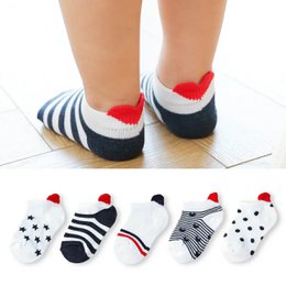 Children's socks in a pack of 5 pairs, available in sizes from 0-12 months to 8-12 years. The socks feature a striped pattern in navy blue, white, and red, with a heart-shaped design on the toe.