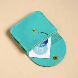 Compact mint green leather wallet with zipper closure and multiple card slots.