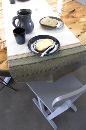 Olive green woven cotton table runner with medium size, suitable for dining table decor.