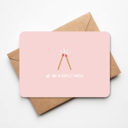 A pink greeting card with the text "We are a perfect match" and a heart-shaped design, suitable for love and romance.