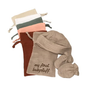 Tüte mit meinen ersten Sachen mit Mütze und Kratzhandschuhen