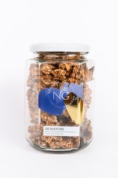 Crunchy granola with a mix of oats, nuts, and dried fruit in a glass jar.