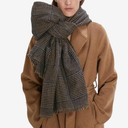 A brown and black plaid scarf with a soft, cozy texture. The scarf has a classic houndstooth pattern and is made of a warm, wool-blend material.