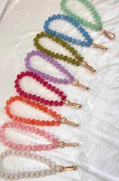  Colorful beaded phone cord holders in various shades including fuchsia, light pink, light blue, lavender, mint green, coral, and pistachio. The cords feature heart-shaped beads and a gold-tone clasp.