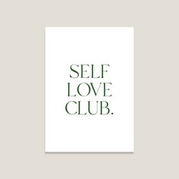 A white postcard with the text "SELF LOVE CLUB" printed in green. The postcard is displayed on a neutral background with some natural elements like flowers.