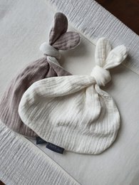 A soft, plush off-white cuddle cloth with a button rabbit design, perfect for snuggling and comforting.