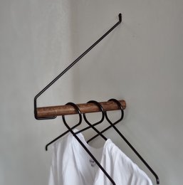 Smoked oak look clothing rack with 3 hooks for hanging clothes.