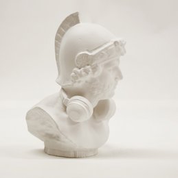 A white, minimalist statue depicting a Roman warrior or soldier with a helmet and ornate details. The statue has a sleek, modern design and appears to be made of a smooth, polished material.