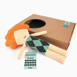 Plush doll with orange hair, green and black argyle pattern dress, and a friendly expression.