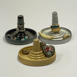  A round, decorative ring holder in white, speckle, and dark chocolate colors. The holder features a raised platform with a circular base to display and organize rings.
