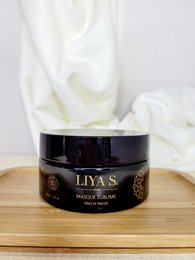 Honey and neroli infused cream mask in a black jar with gold accents.