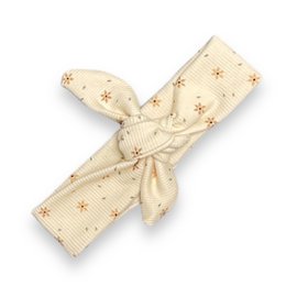 A cream-colored headband with a knot design and small star patterns. Suitable for children.