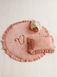 Soft, plush velvet rug in a warm apricot color with a ruffled edge and heart-shaped design, perfect for a child's bedroom or playroom.