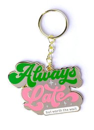 Keychain with the text "Always late but worth the wait" in a stylized green and pink design.