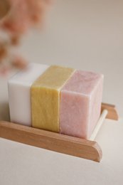 Rectangular bamboo soap dish with a pink and yellow soap bar.