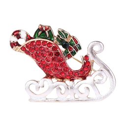 Sparkling red rhinestone brooch in the shape of Santa's sleigh, with green and white accents. Festive holiday jewelry piece.
