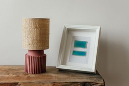 Chic pink raffia shade table lamp with a modern, minimalist design.